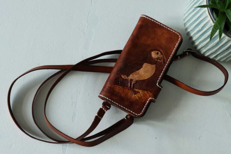 Handyhülle zum umhängen aus Leder, Individuelle Punzierung, Prägung ,mit Papageitaucher Motiv, Unikat, liebevolle Handarbeit, Handbemalt. Auch ein schönes Geschenk, Astrid Preisler ARTWORK