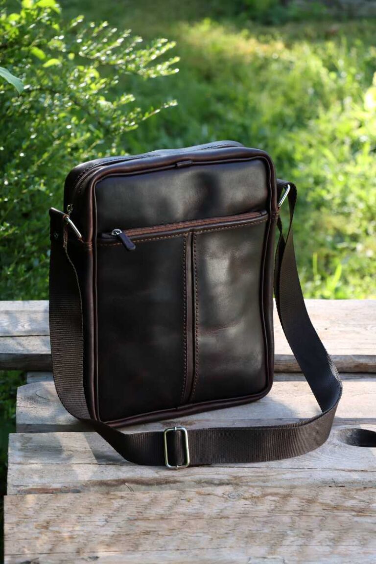 Eine wunderschöne dunkelbraune Herren Ledertasche. Komplettansicht von vorne. Handgenäht von Astrid Preisler ARTWORK. Die Tasche hat mit Leder Bezogene Reisverschlüsse. Der Schulterriemen ist aus Nylonband und verstellbar.